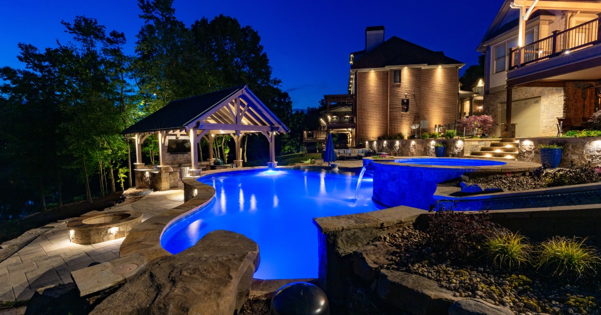 swimming pool at dusk with lighting and spa